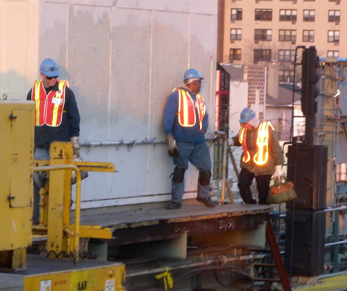 Construction workers in high-visibility vests and hard hats on a city job site